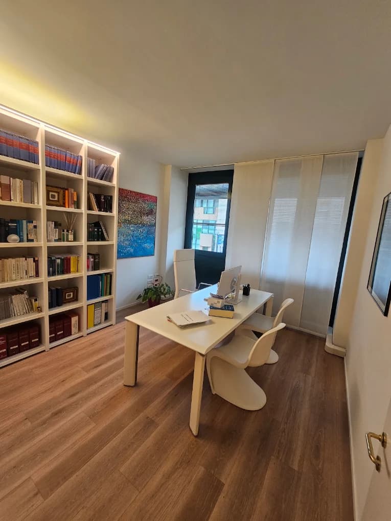 Studio professionale ordinato con libreria e scrivania bianca